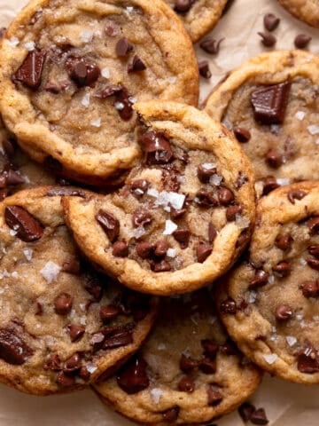 miso chocolate chip cookies in a pile on parchment paper.