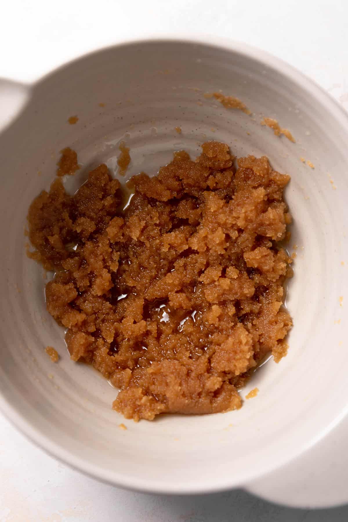 a mixing bowl with browned butter and sugar mixed together.
