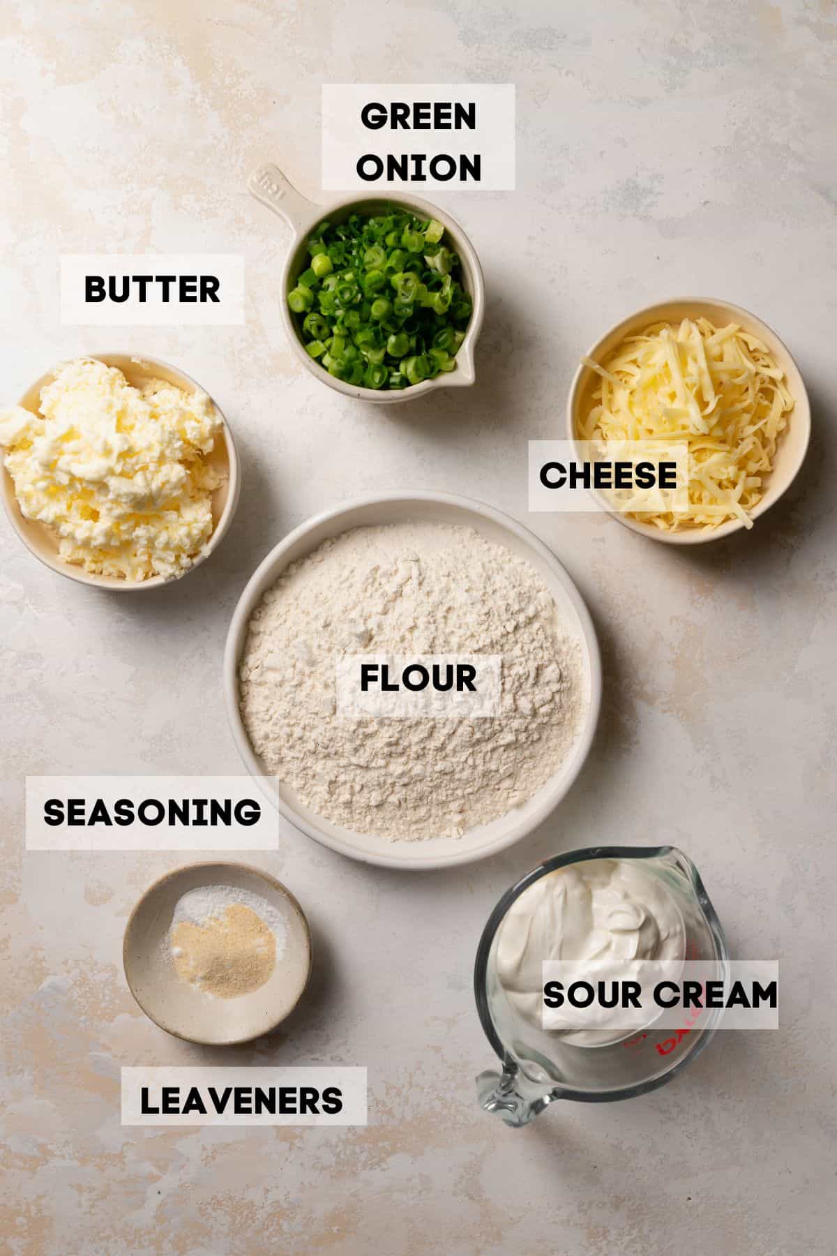 ingredients needed to make biscuits in bowls with labels.