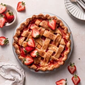strawberry peach pie in a pie plate with fresh berries.