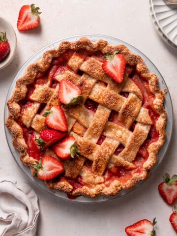 strawberry peach pie in a pie plate with fresh berries.