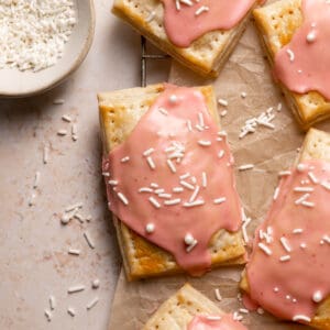 homemade strawberry pop tarts with pink glaze and white sprinkles.