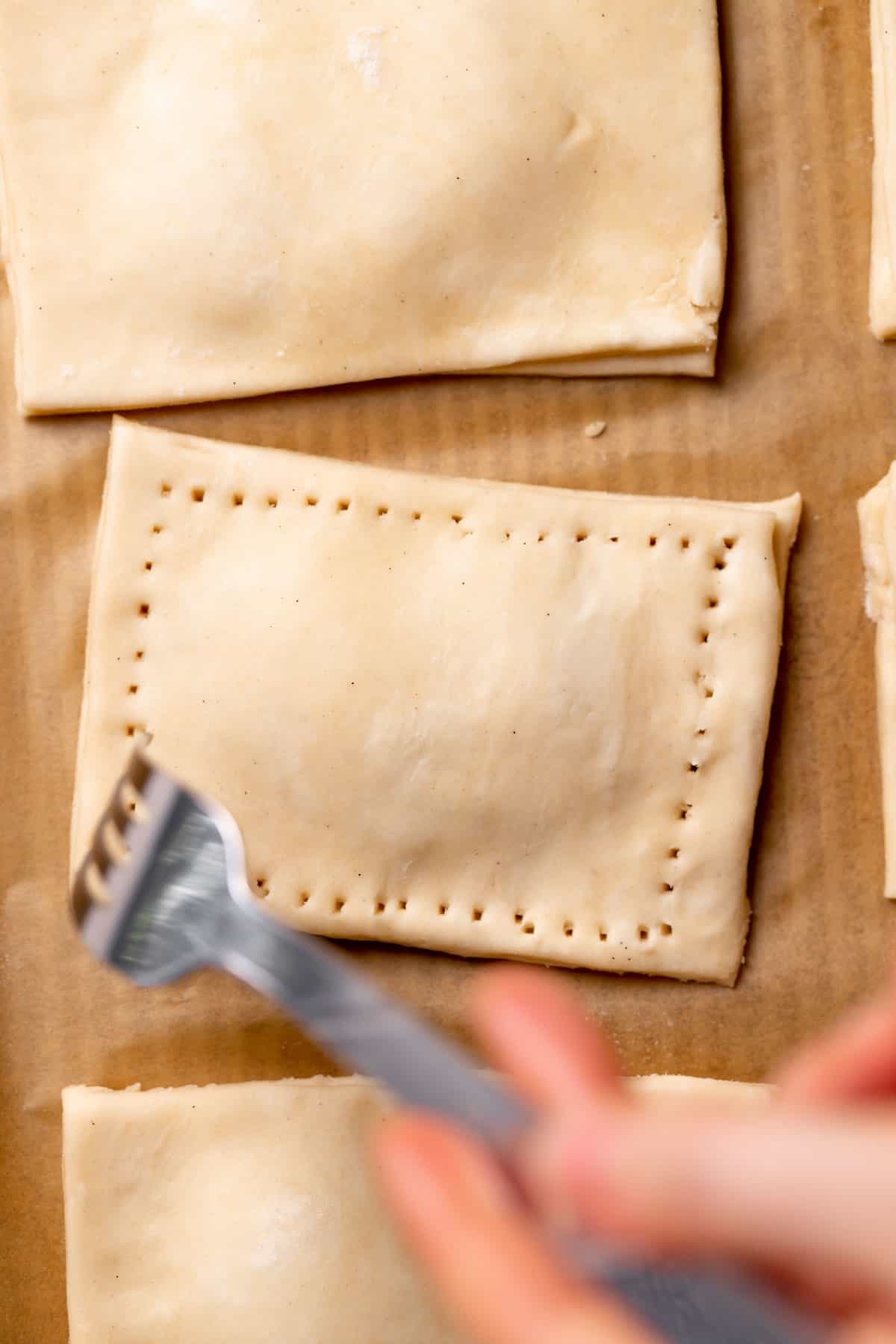 a fork crimping the edges of the pop tarts.