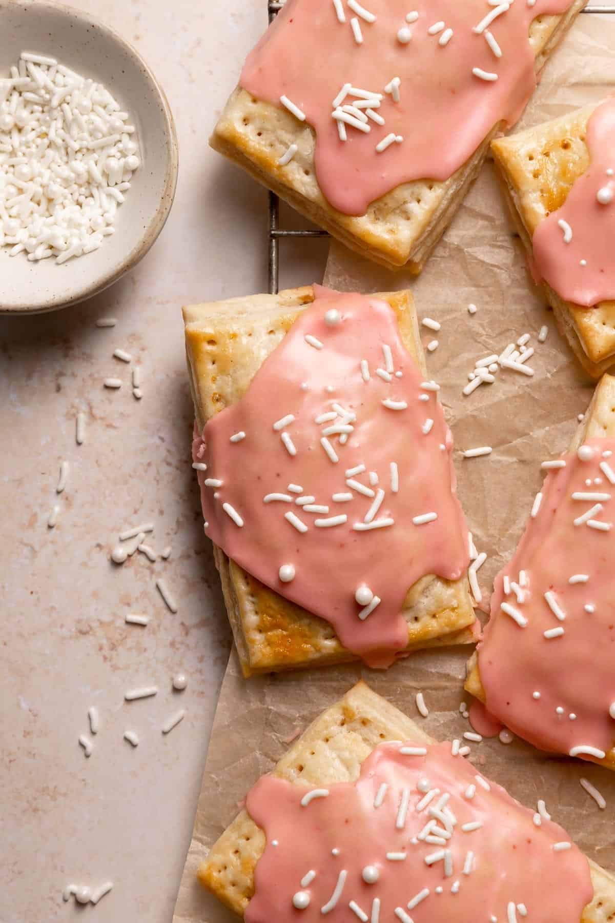 homemade pop tarts with pink glaze and white sprinkles.