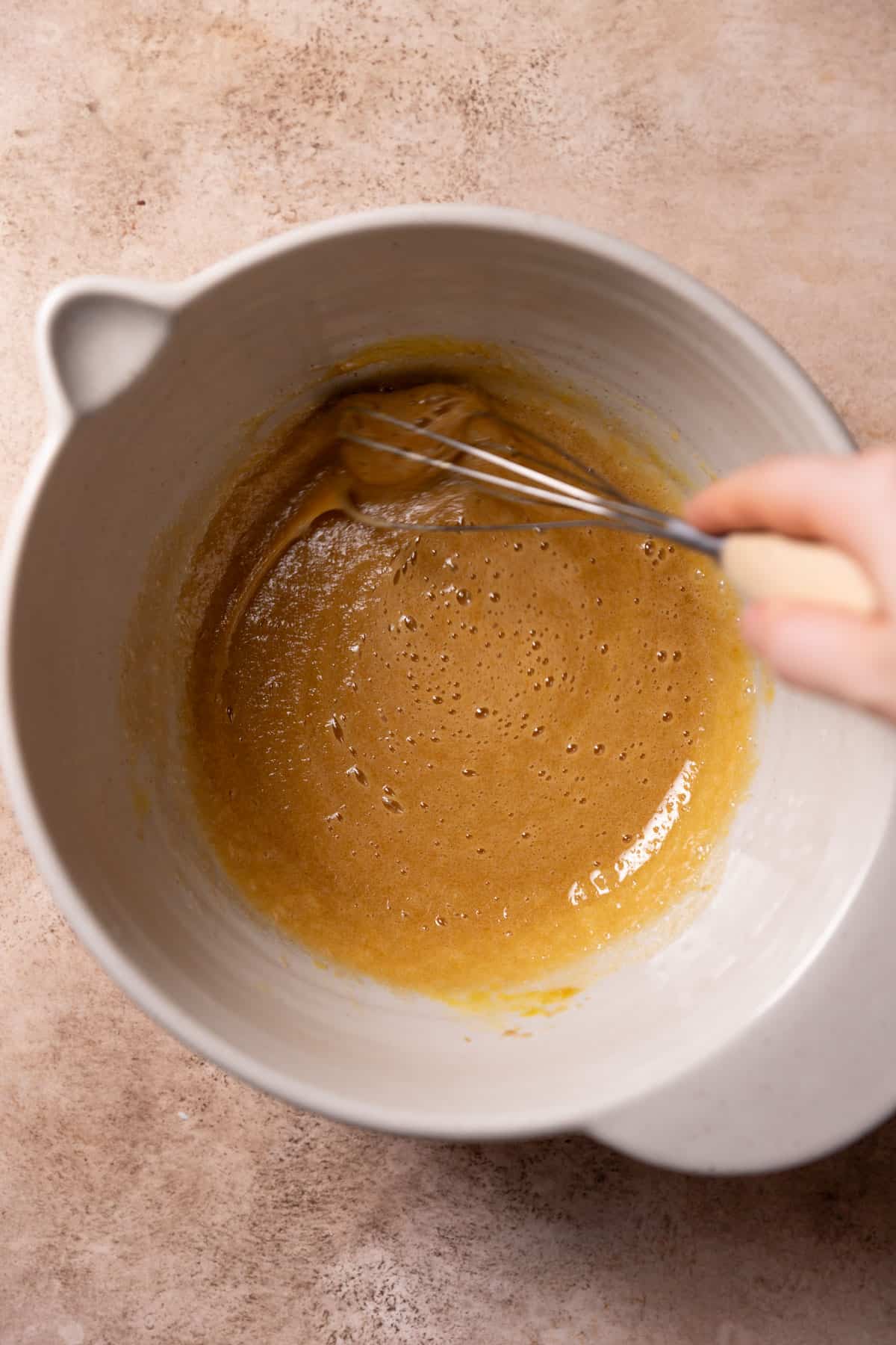 whisking the sugar and eggs together in a mixing bowl.