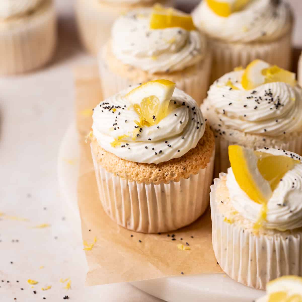 lemon poppy seed cupcakes on a white marble plate.