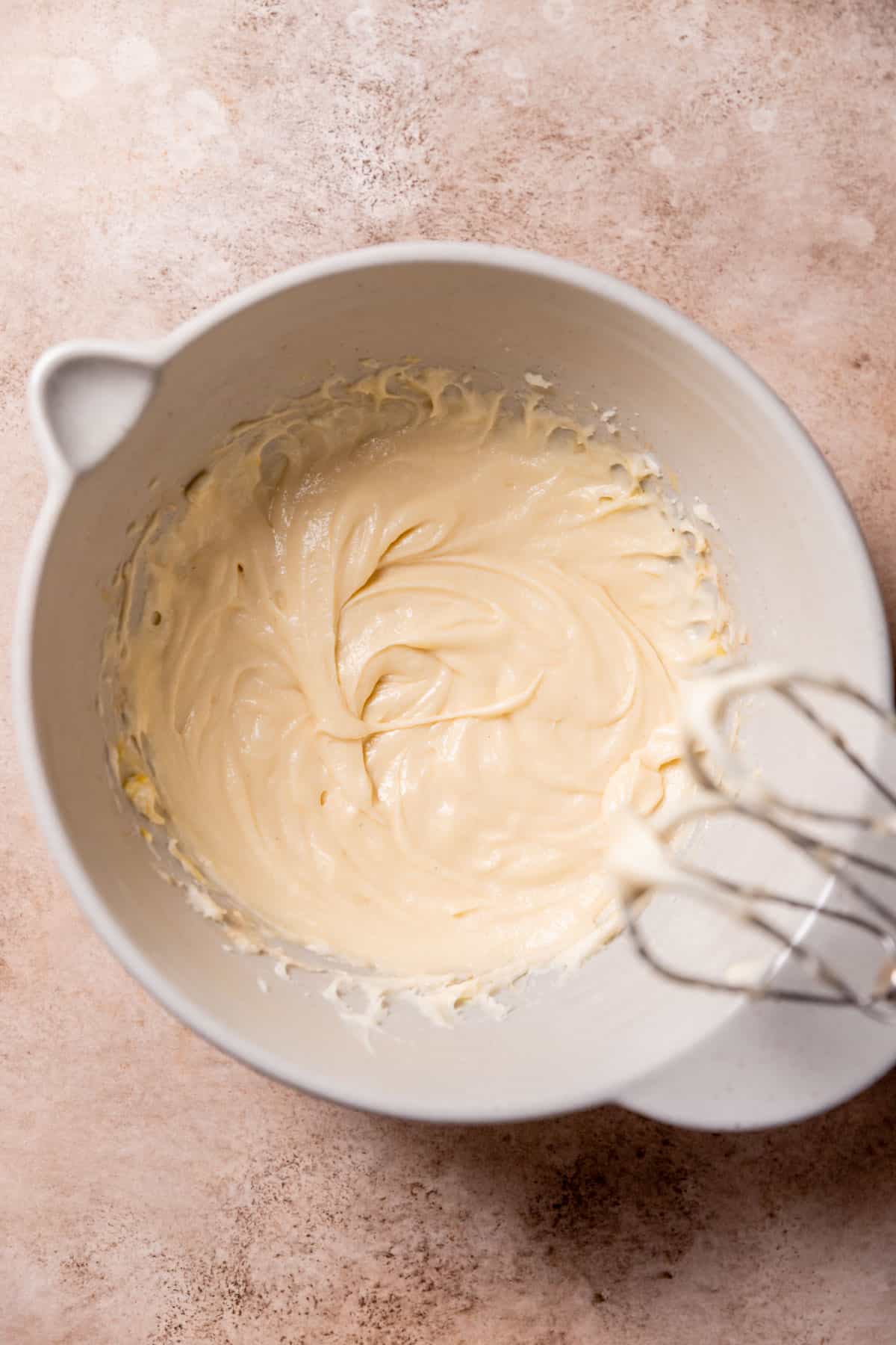 butter, sugar, and eggs mixed together in a mixing bowl.