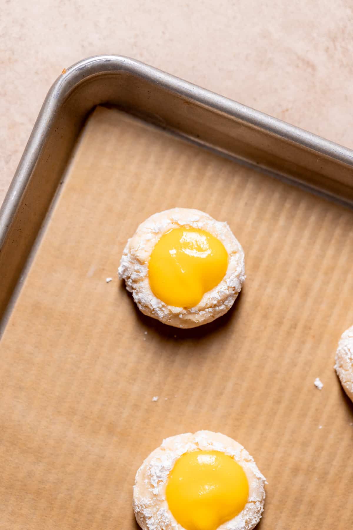 cookie filled with mango curd on a baking tray before baking.