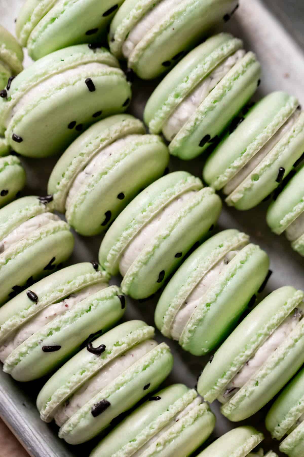 mint chocolate macarons on a baking tray.