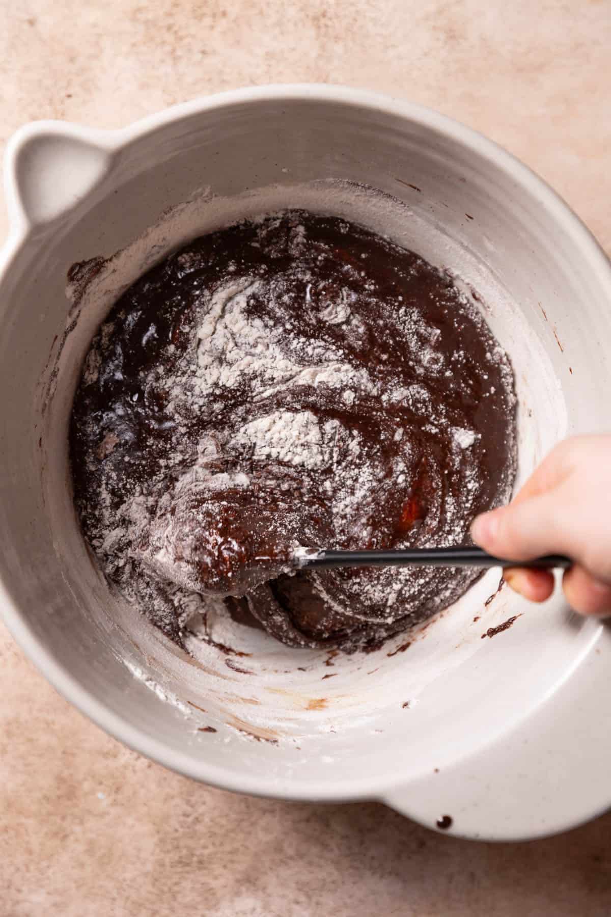 folding the dry ingredients into the brownie batter.