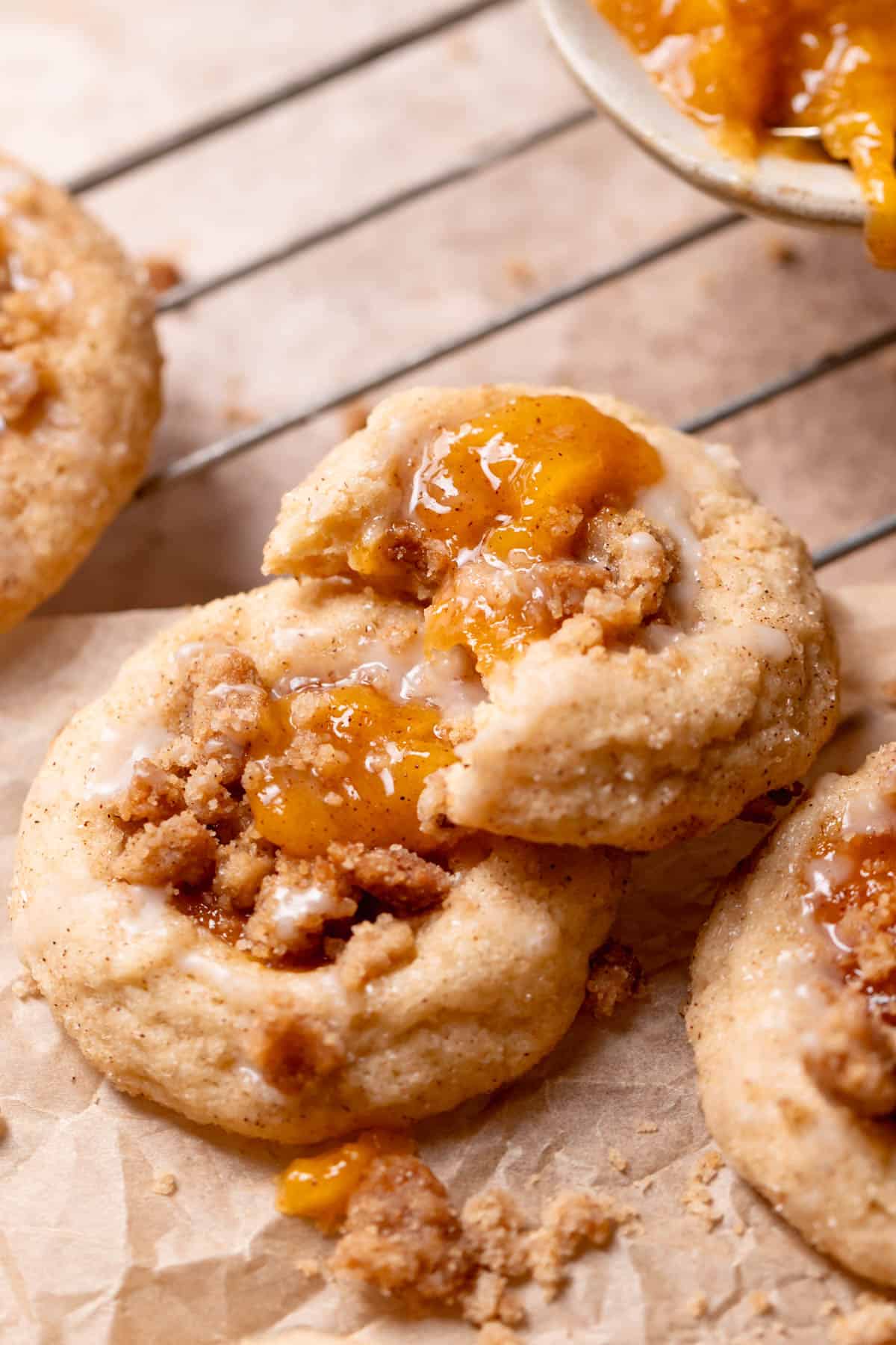 peach cookie with a bite taken out of it on parchment paper.