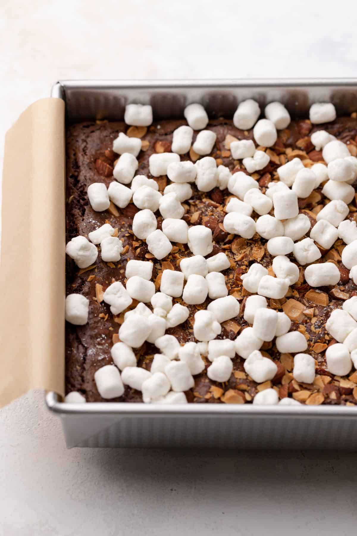mini marshmallows on top of a pan of brownies.