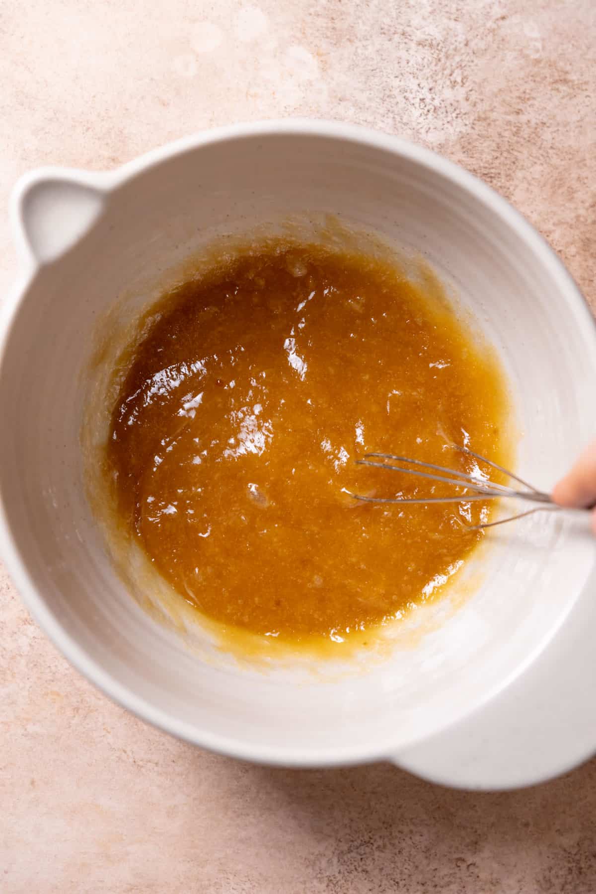 a mixing bowl with the melted butter, sugars, eggs, and vanilla whisked together.