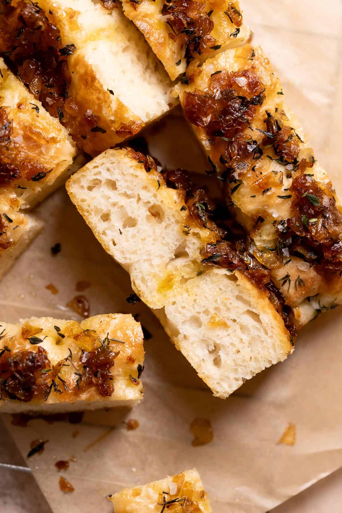 slices of focaccia with caramelized onions on parchment paper.