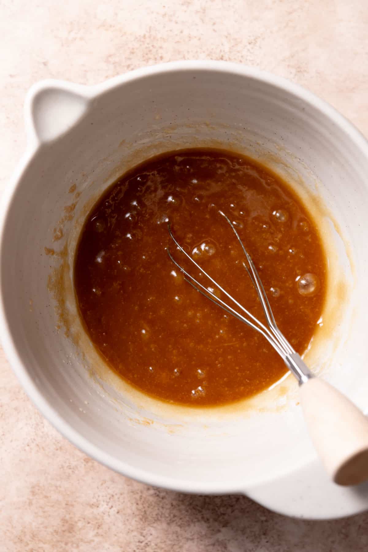 a bowl with the butter, sugar, eggs, and molasses whisked together.