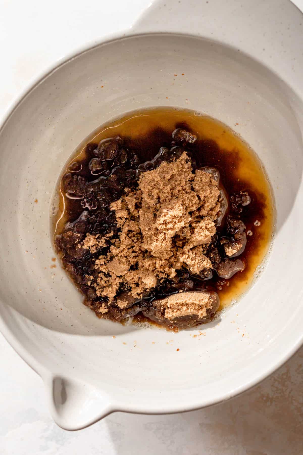 a large bowl with oil, brown butter, and sugar before mixing.