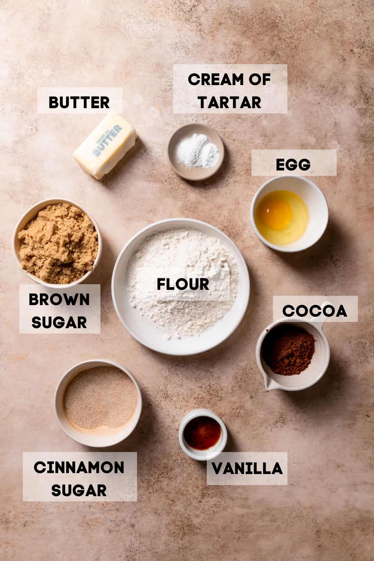 ingredients needed to make chocolate cookies in bowls with labels.