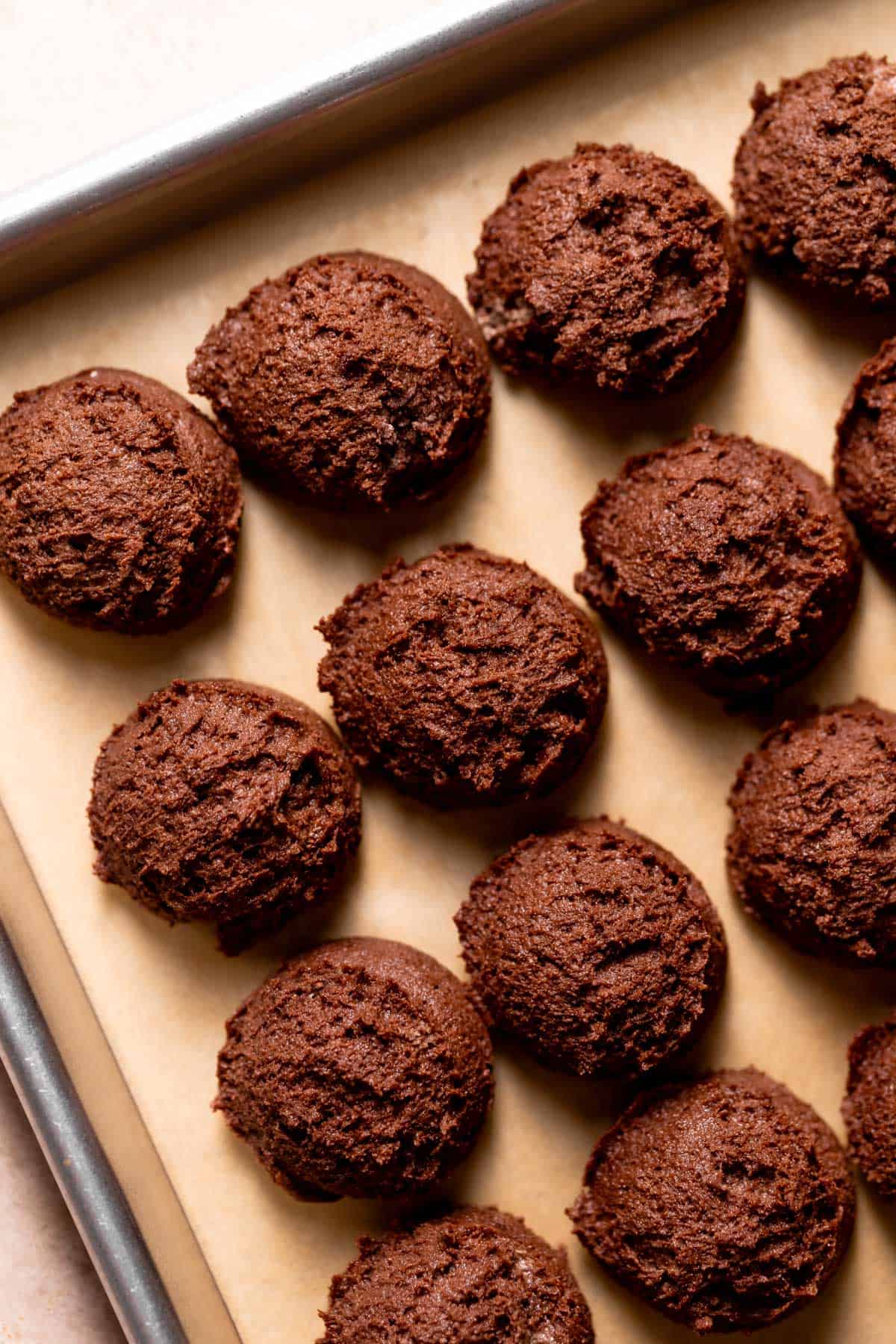 chocolate cookie dough balls on a baking tray.