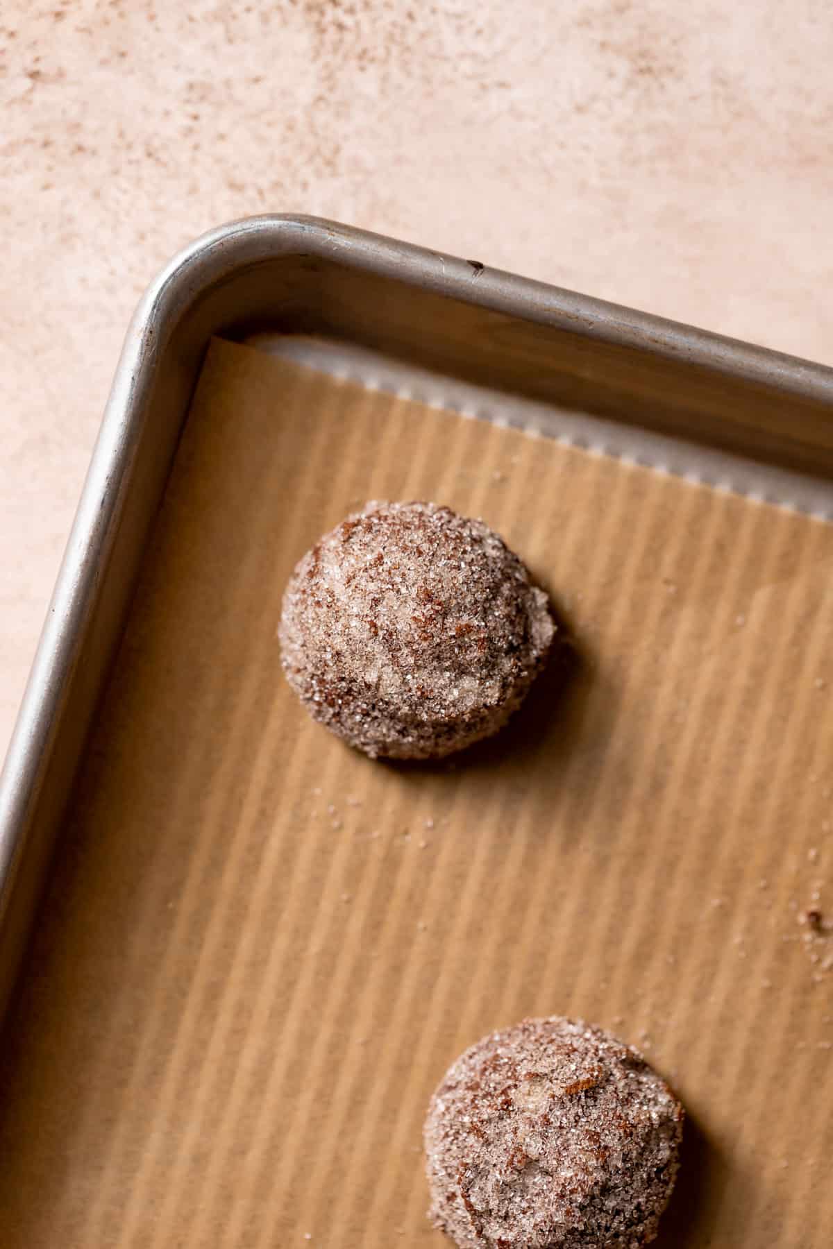 chocolate snickerdoodle cookie dough balls on a baking tray.