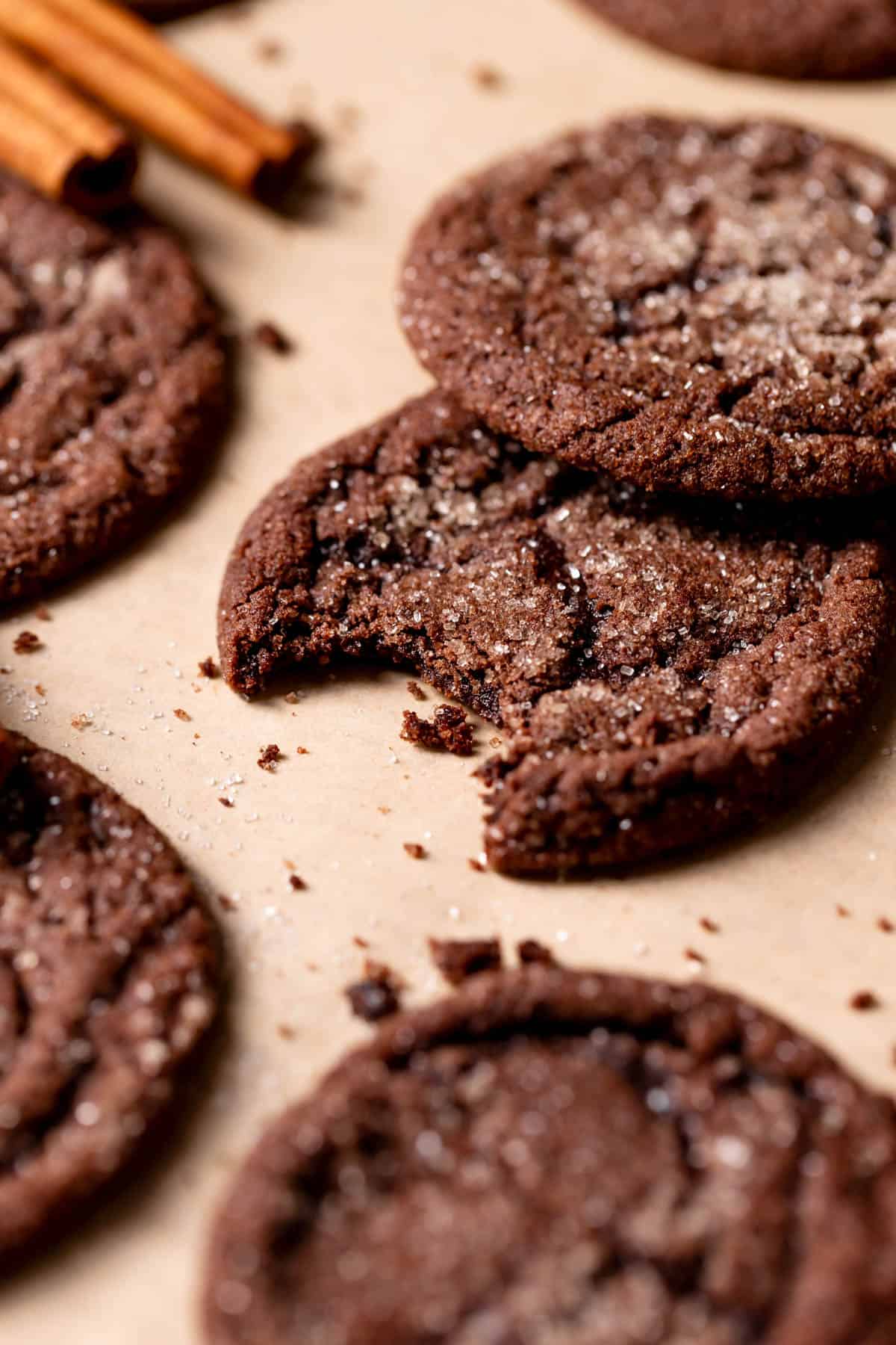 a chocolate cookie with a bite taken out of it on parchment paper.
