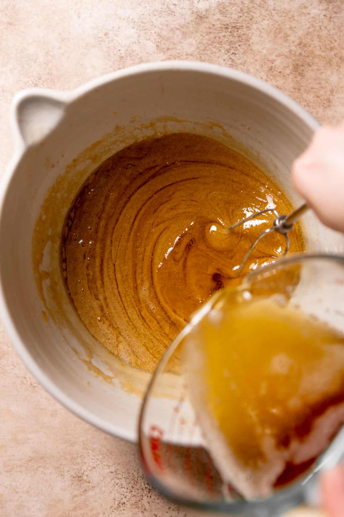 whisking the brown butter into the wet ingredients in a mixing bowl.