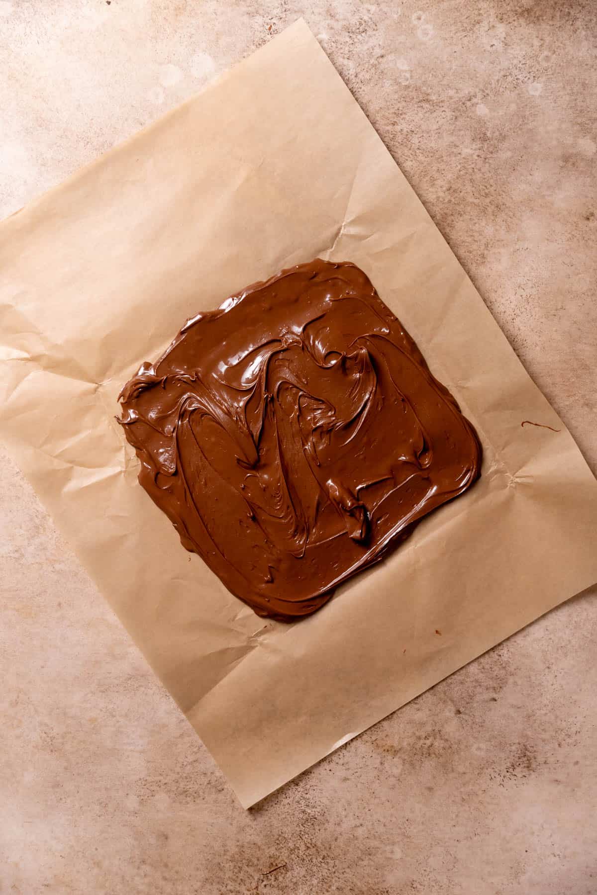 chocolate hazelnut spread smeared into a square on parchment paper.
