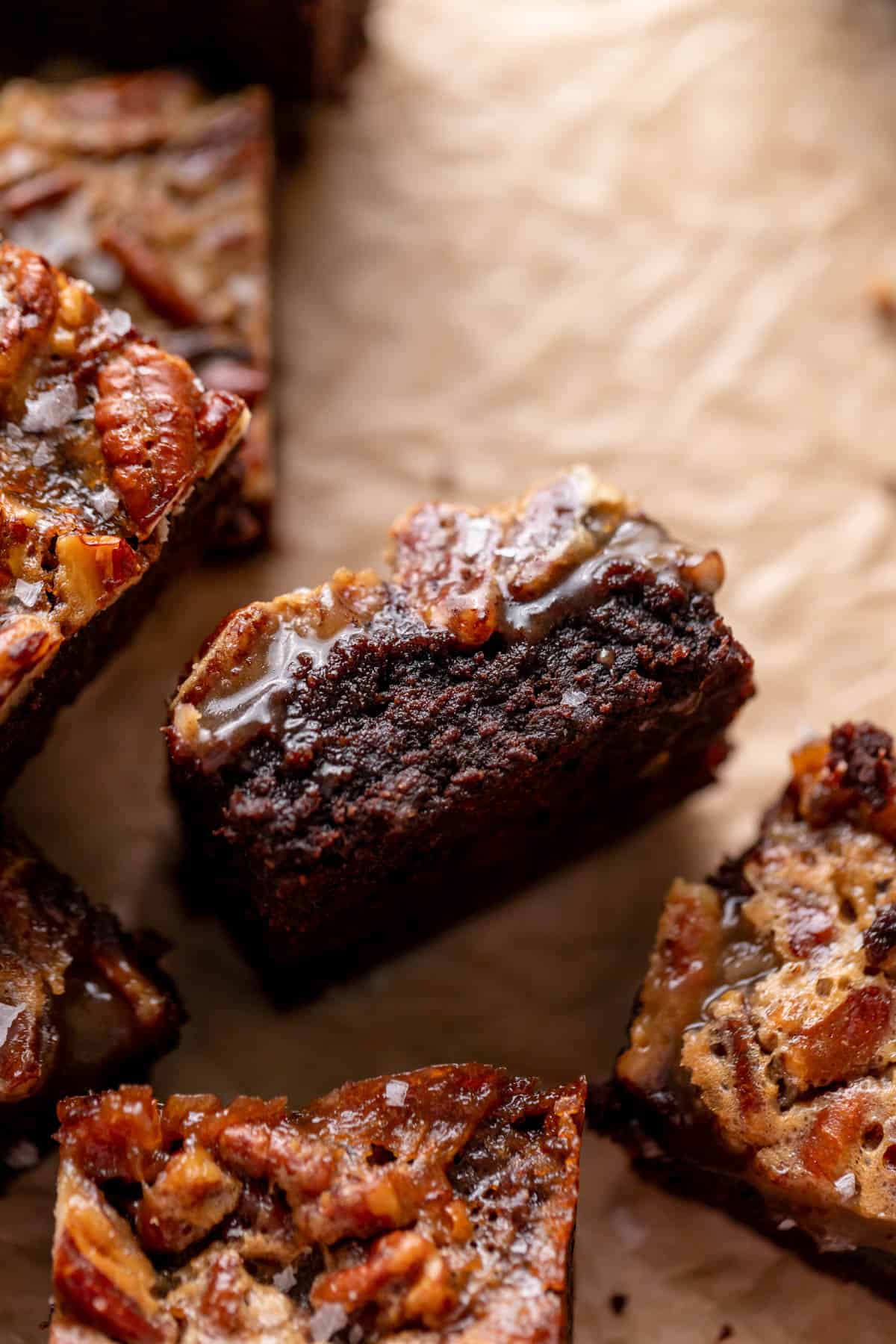 chocolate pecan brownie on its side to show the fudgy texture and gooey pecan pie topping.