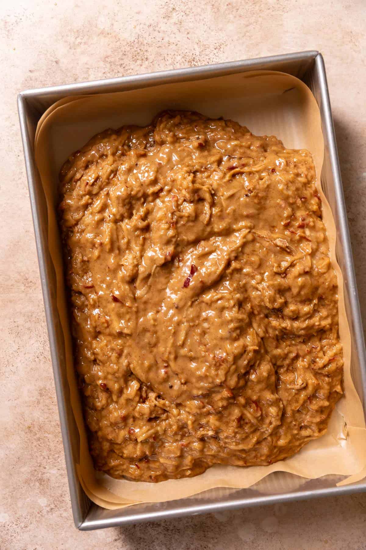 Apple batter spread into a large baking pan.
