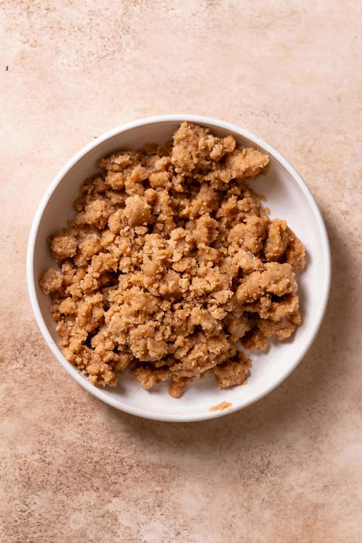 A white bowl with cinnamon crumb topping.