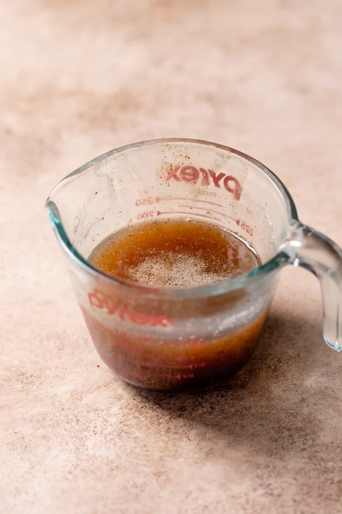 A glass measuring cup with the chilled brown butter inside it.