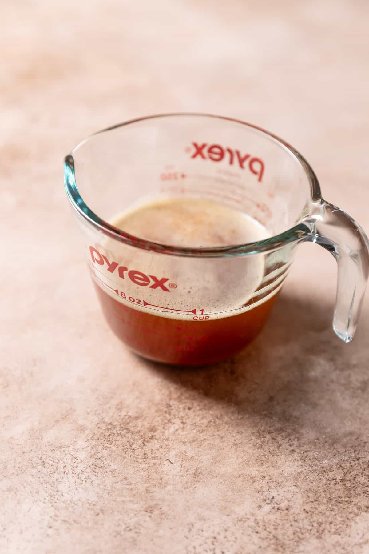 A glass pyrex measuring cup with the liquid brown butter.