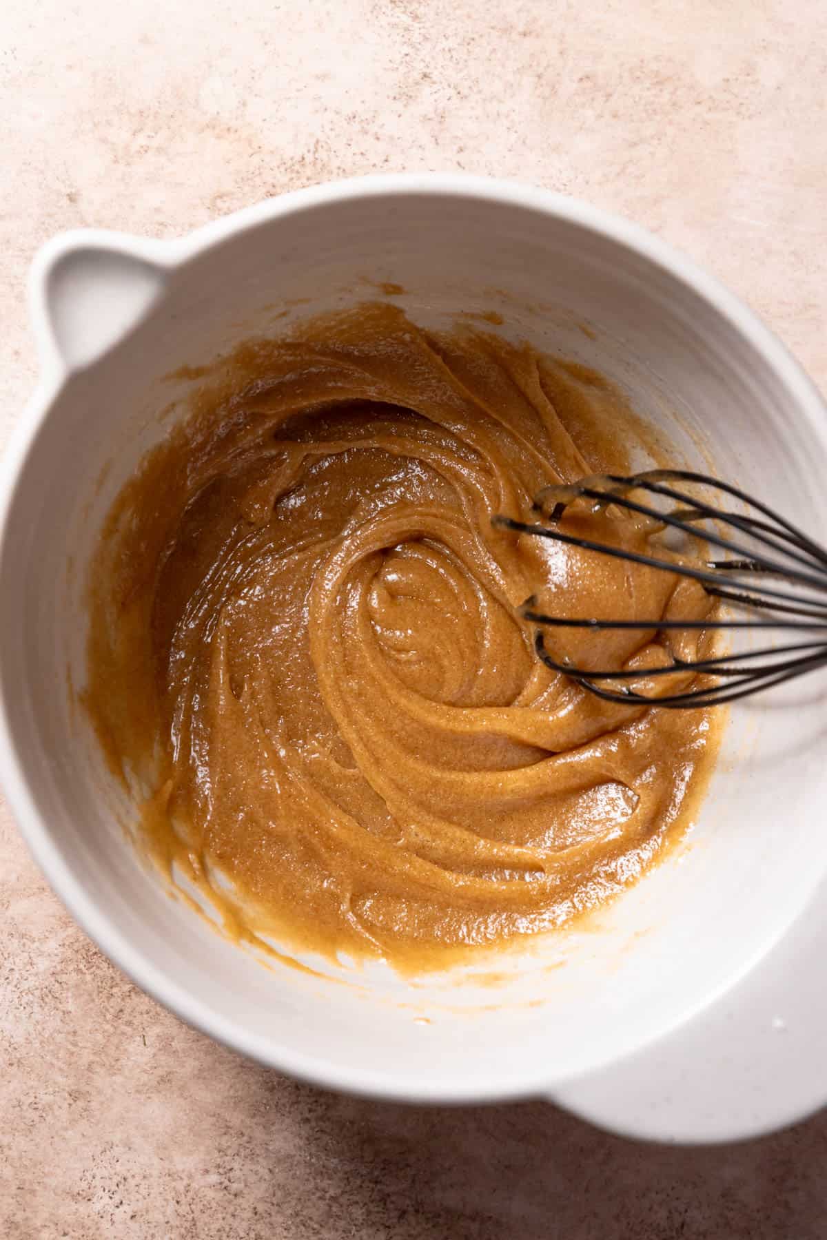 A mixing bowl with the wet ingredients being whisked together.