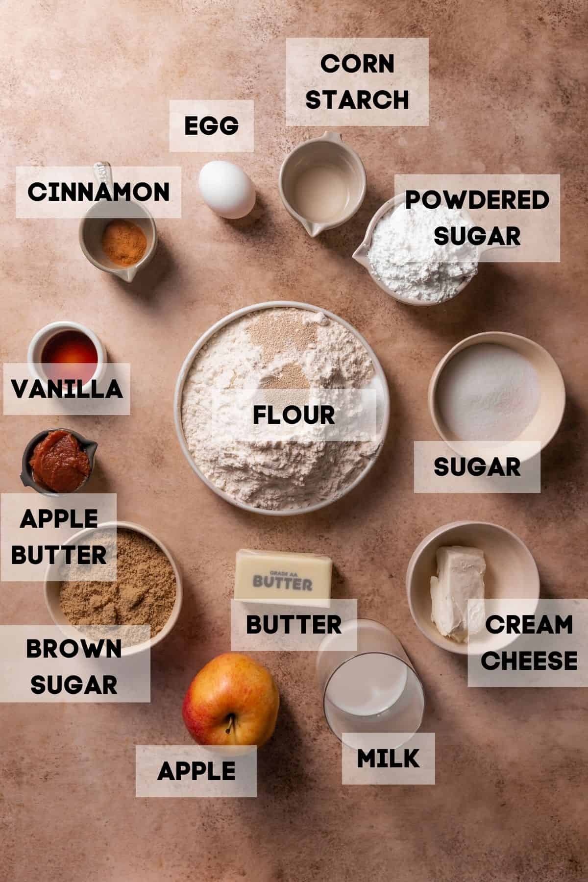 Ingredients needed to make apple cinnamon rolls in bowls with labels.