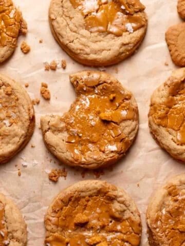 Biscoff butter cookies on a baking tray with melted cookie butter on top of each one.