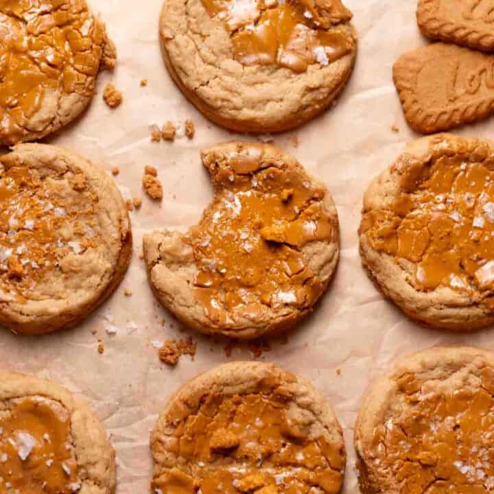 Biscoff butter cookies on a baking tray with melted cookie butter on top of each one.