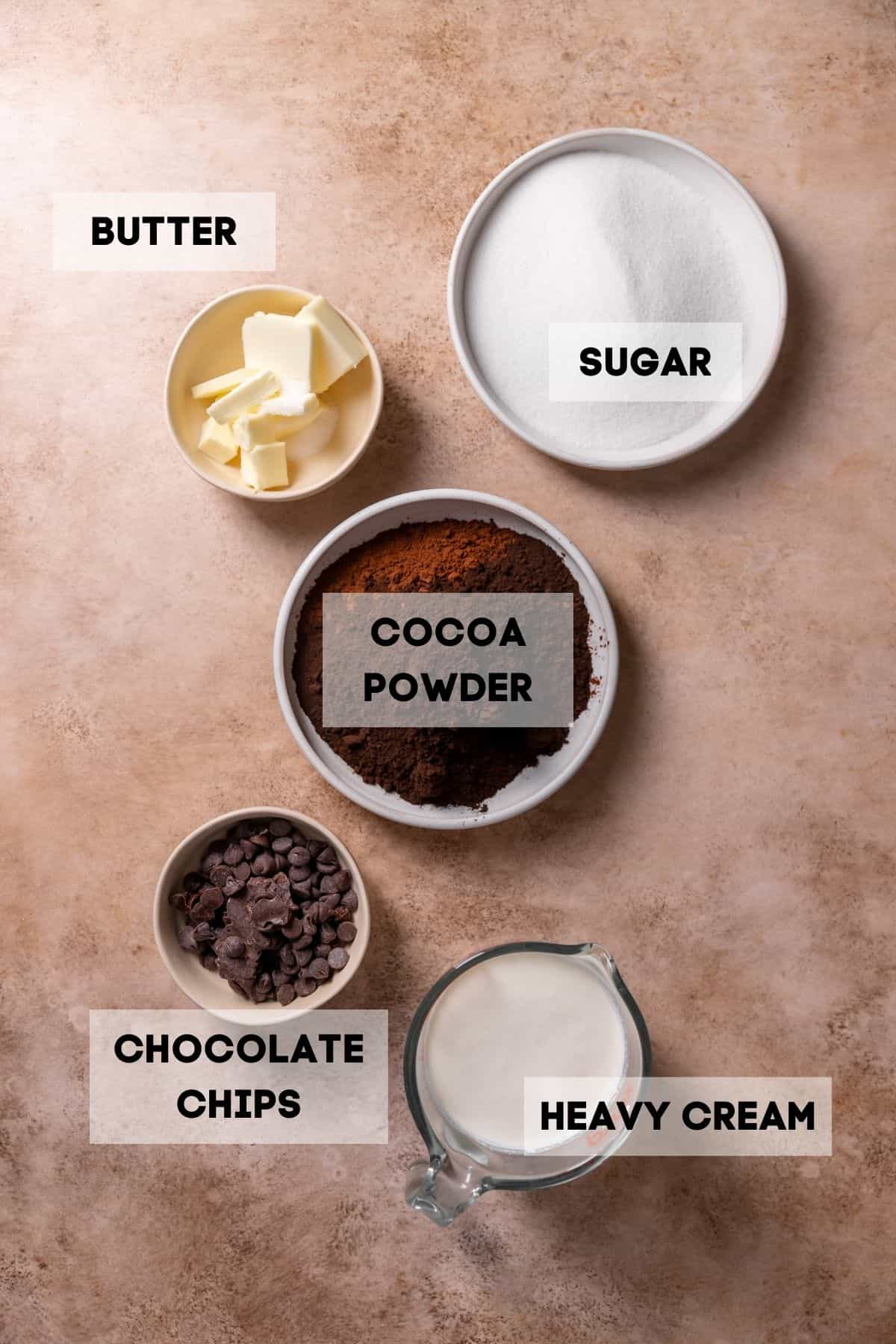 Ingredients needed to make black fudge frosting in bowls with labels.
