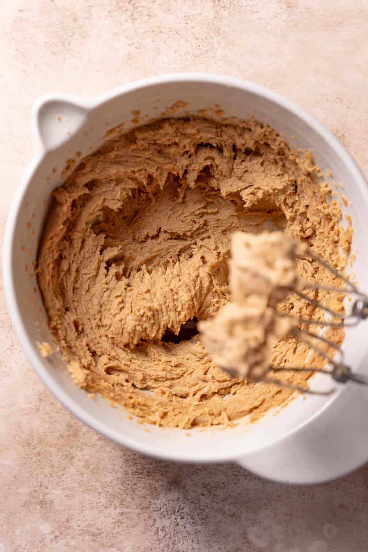A mixing bowl with the creamed butter, sugar, and peanut butter.