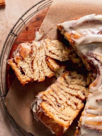 Cinnamon roll cake slices on a wooden platter on their sides to show the cinnamon swirl texture.