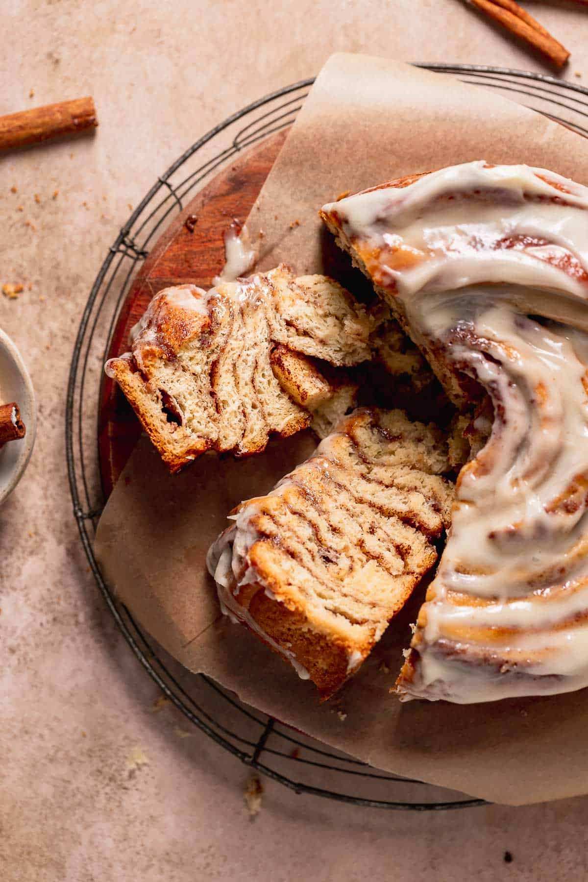 Cinnamon roll cake slices on a wooden cake board on their side to show the cinnamon swirl texture.
