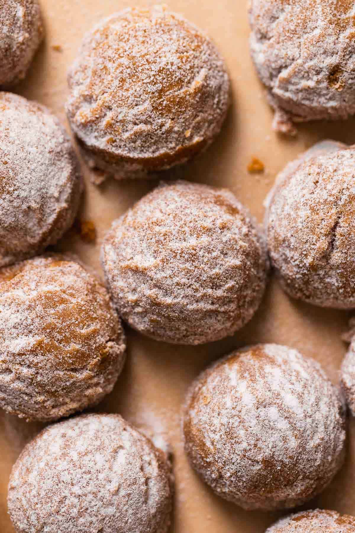 Molasses cookie dough balls rolled in sugar on a baking sheet.