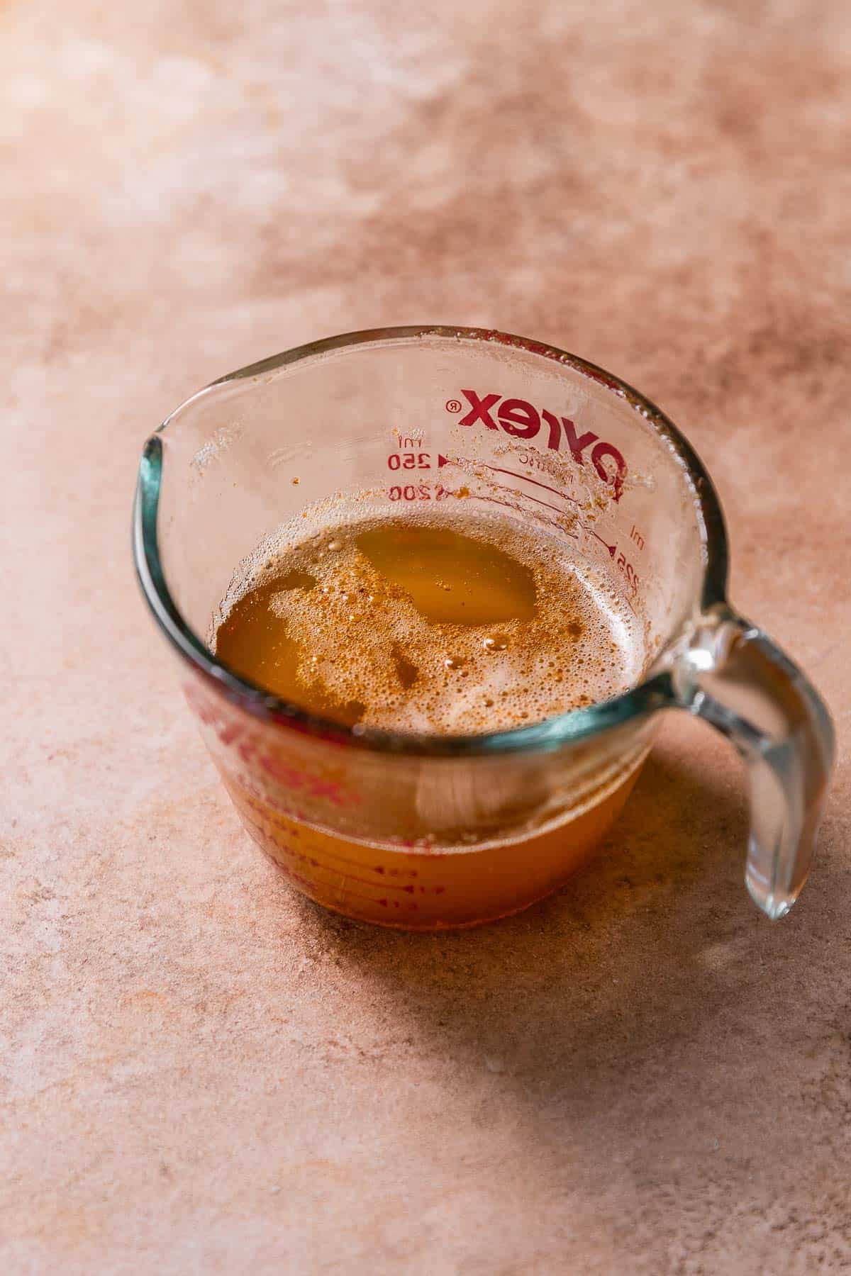 A glass measuring cup with melted brown butter.