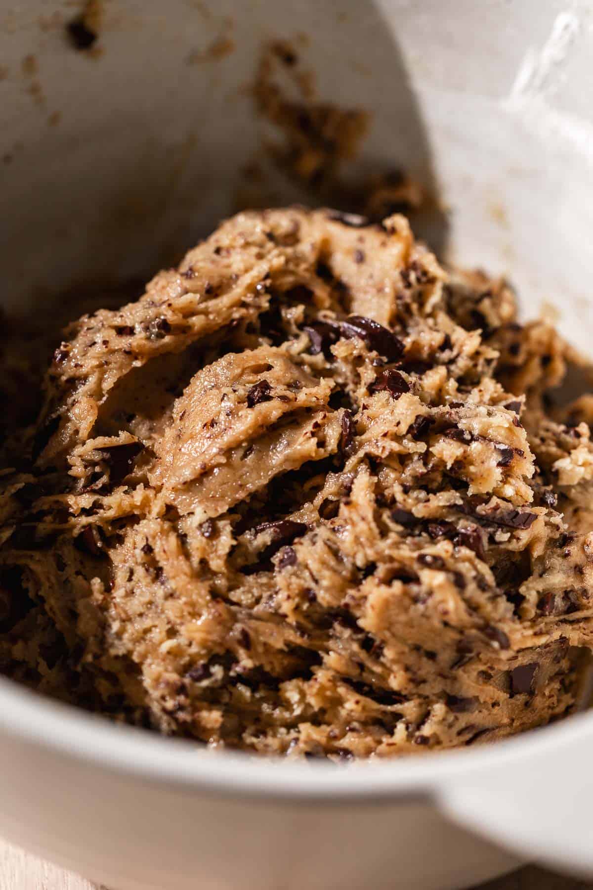 A mixing bowl with the chocolate chip cookie dough after mixing in the dry ingredients.