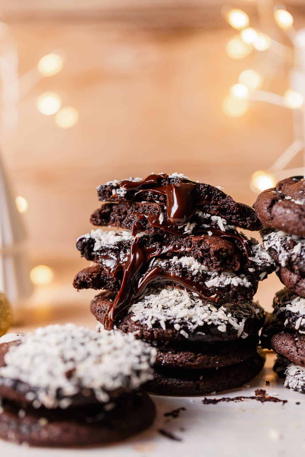 A stack of chocolate cookies with fudge filling oozing out.