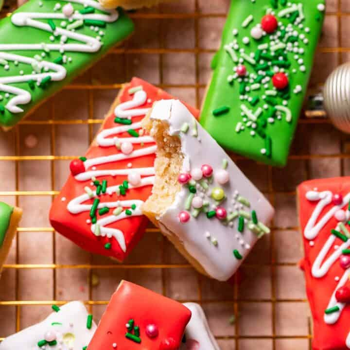Christmas sugar cookie bars with festive sprinkles on a gold wire rack.