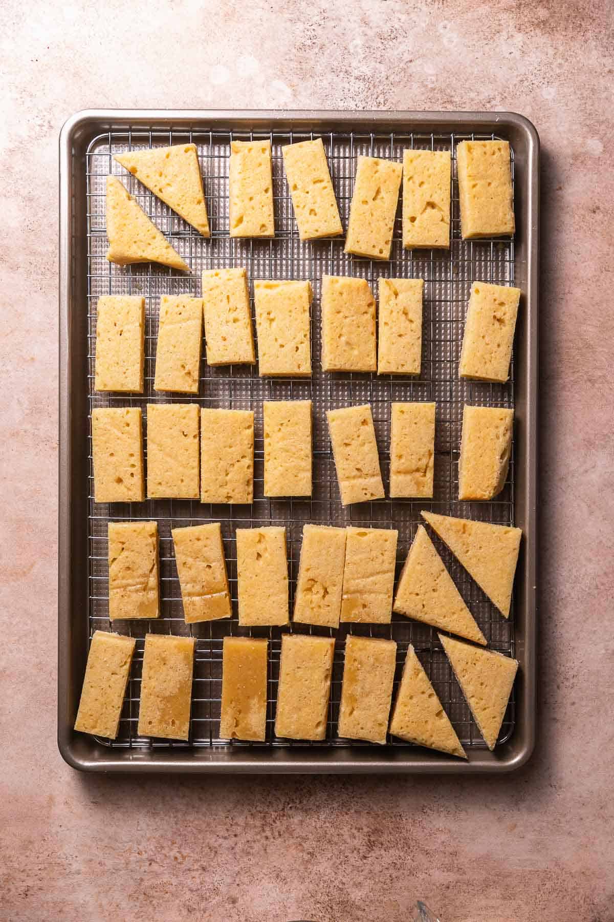 Cut sugar cookie bars on a wire rack and sheet pan.