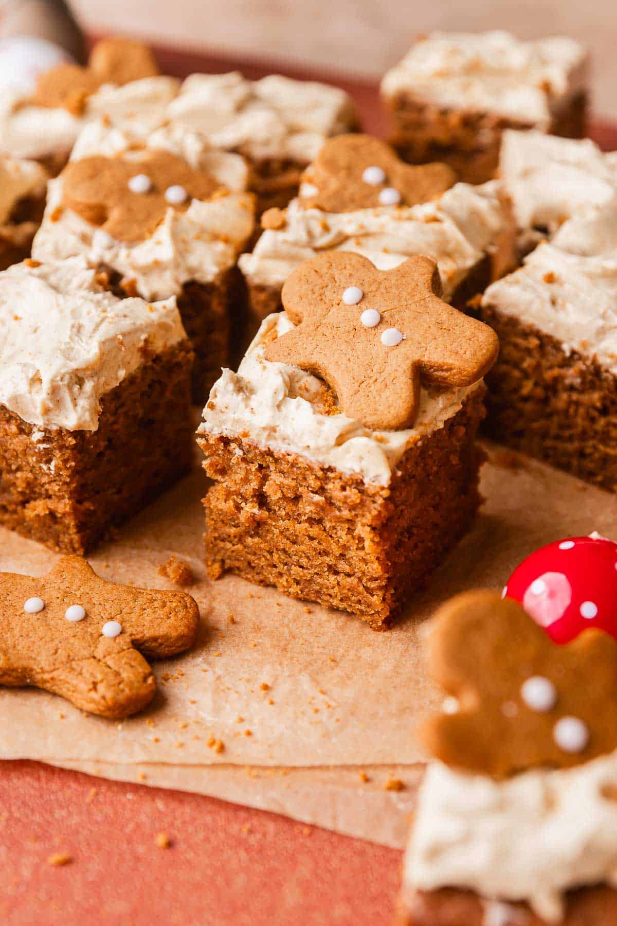 Slices of gingerbread cake with molasses frosting and mini gingerbread cookies on top.