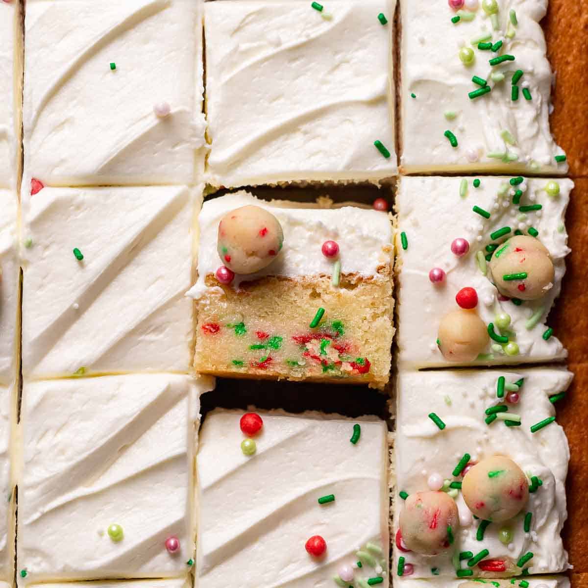 A slice of sugar cookie cake on its side to show the sugar cookie dough layer.