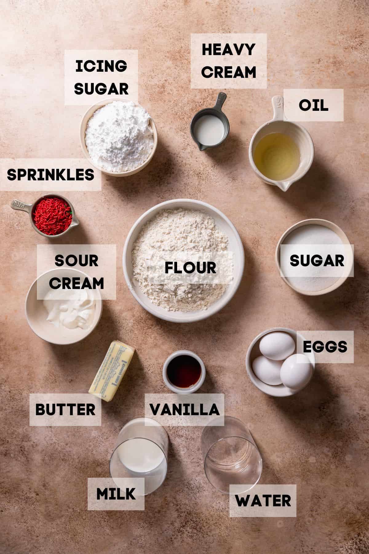 Ingredients needed to make frosted sugar cookie cake in bowls with labels.