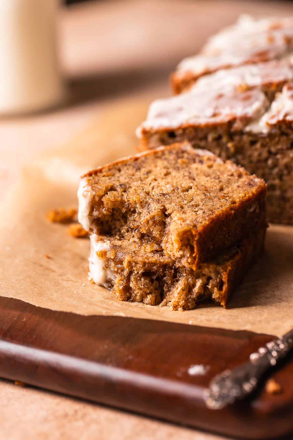 A slice of banana bread broken in half to show the moist and tender texture.
