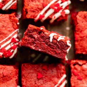 Fudgy red velvet brownies with cream cheese icing and red heart sprinkles.